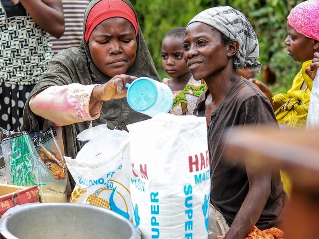 women sharing sacks of posho flour during a wehat foundation welfare outreach